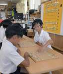児童クラブで将棋の腕を磨く児童ら。５年の塩手遥之さん（右）が選手兼指導役を担う＝指宿市山川の山川児童クラブ
