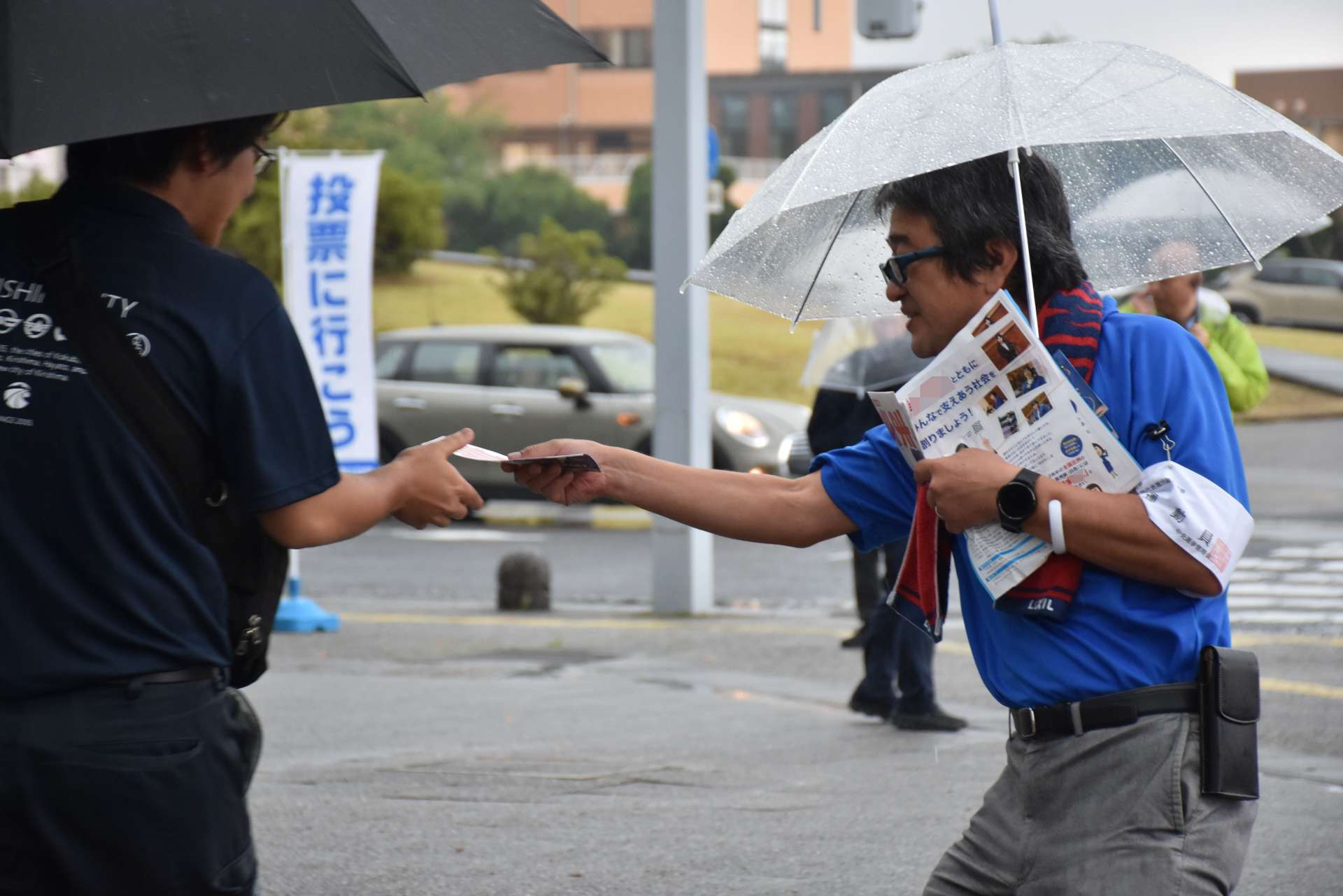 応援する候補者のチラシを配る自治労鹿児島県本部＝１６日、霧島市役所前（画像の一部を加工しています）