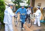 自転車乗車時のヘルメット着用を呼びかけるチラシを手渡す警察官＝１４日午前８時前、鹿児島市の鶴丸高校