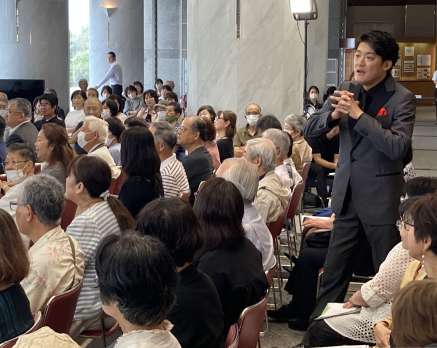約３００人の聴衆の前で歌うテノールの西村悟さん＝１８日、鹿児島市の県庁