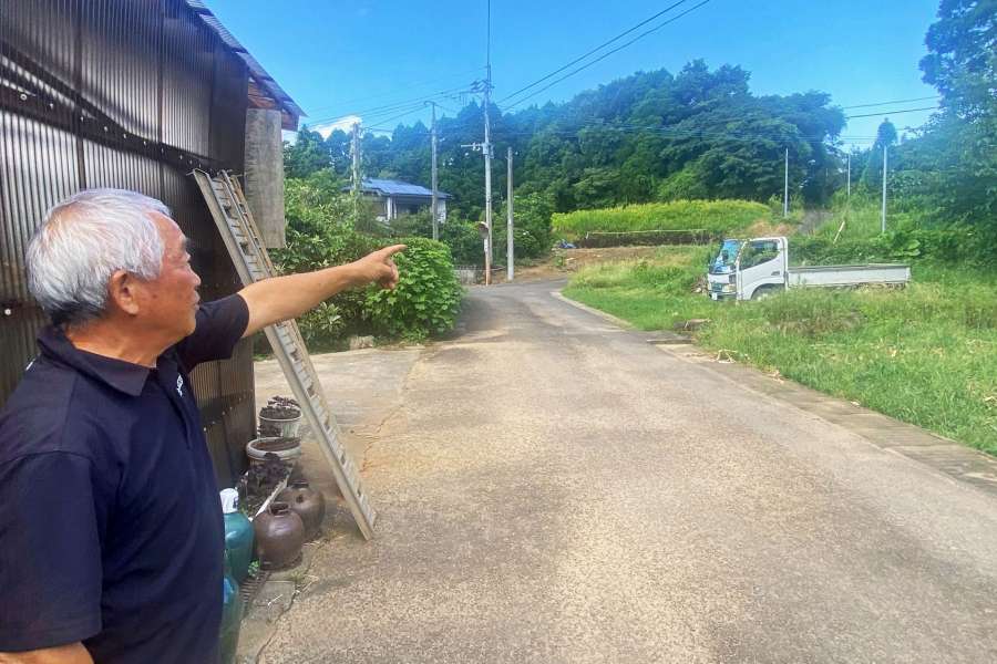 水俣病特措法で被害救済の判断が分かれた旧長島町と旧東町の境を示す上田正幸さん＝長島町平尾