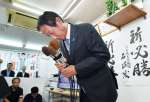 敗戦の弁を述べ、支持者に頭を下げる園田修光さん＝２０日午後８時１８分、鹿児島市郡元２丁目