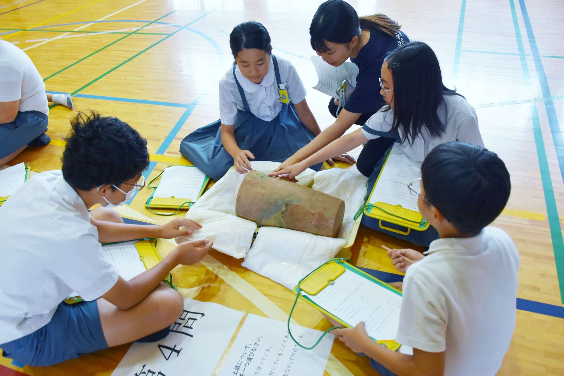 土器を触ってクイズの答えを考える児童ら＝霧島市国分中央２丁目の国分小学校