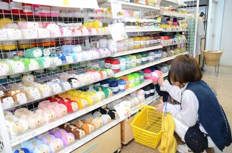 〈今日は何作ろうかな〉毛糸を手に取る客＝鹿児島市の手芸のまきの天文館店