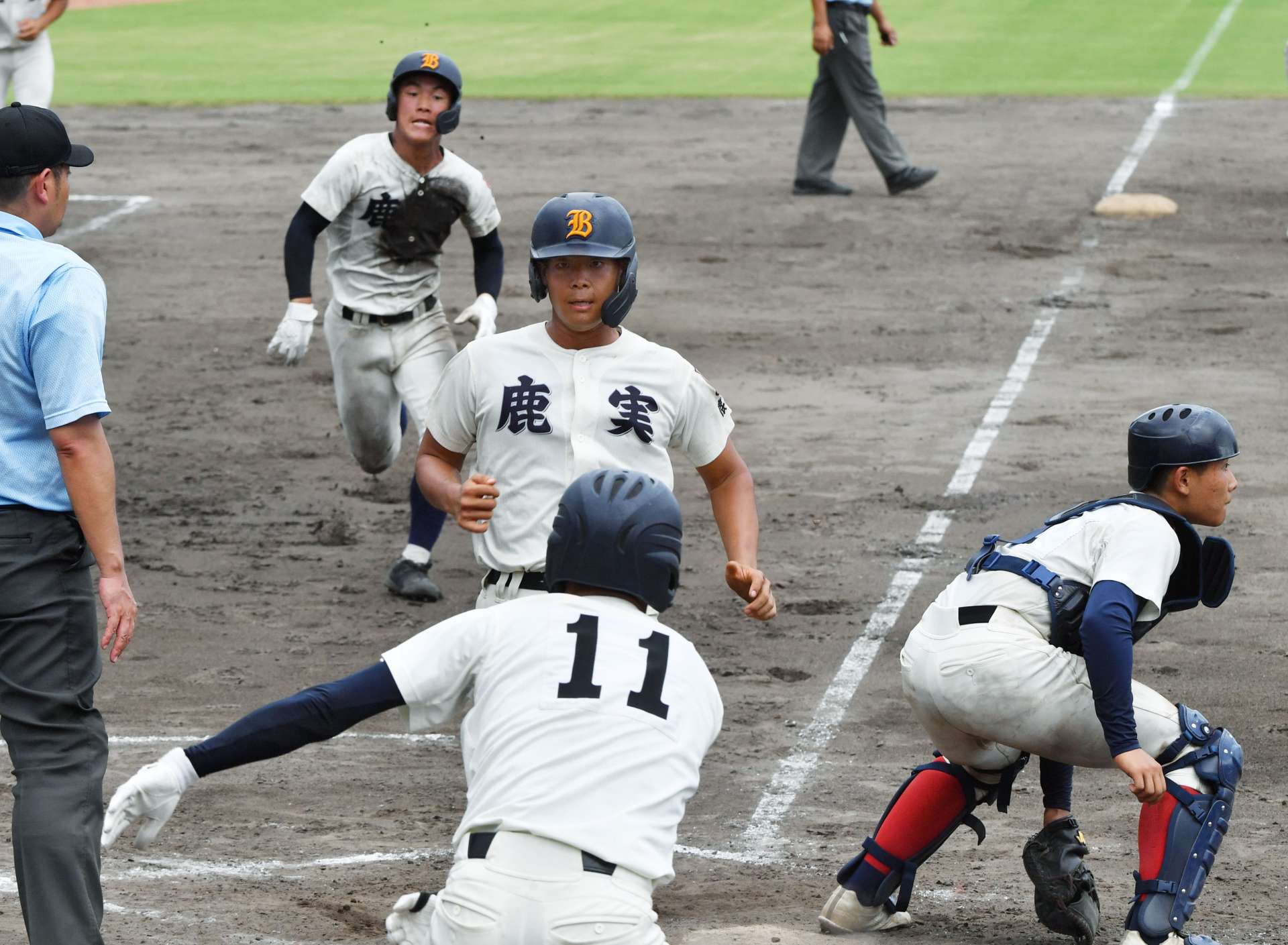 ９回表鹿実１死二、三塁、枦川の右前打で三走島田（手前）に続き中村真が生還する＝平和リース
