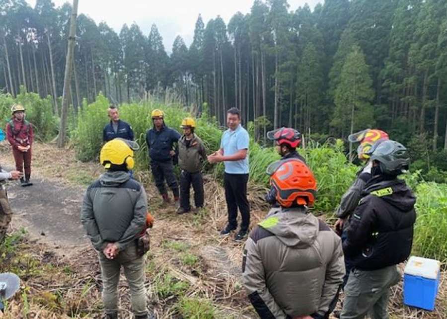 再造林に欠かせない雑草の下刈り作業を学ぶ県内の若手林業関係者ら＝１５日、南九州市川辺（和興産業提供）