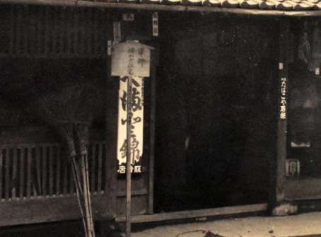 「軍神　横山少佐宅」と墨書された木札が立つ戦時中の横山家（黎明館提供）