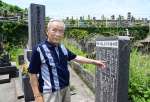 「軍神　横山正治少佐の碑」前に立つ横山正照さん＝７月５日、鹿児島市郡元町