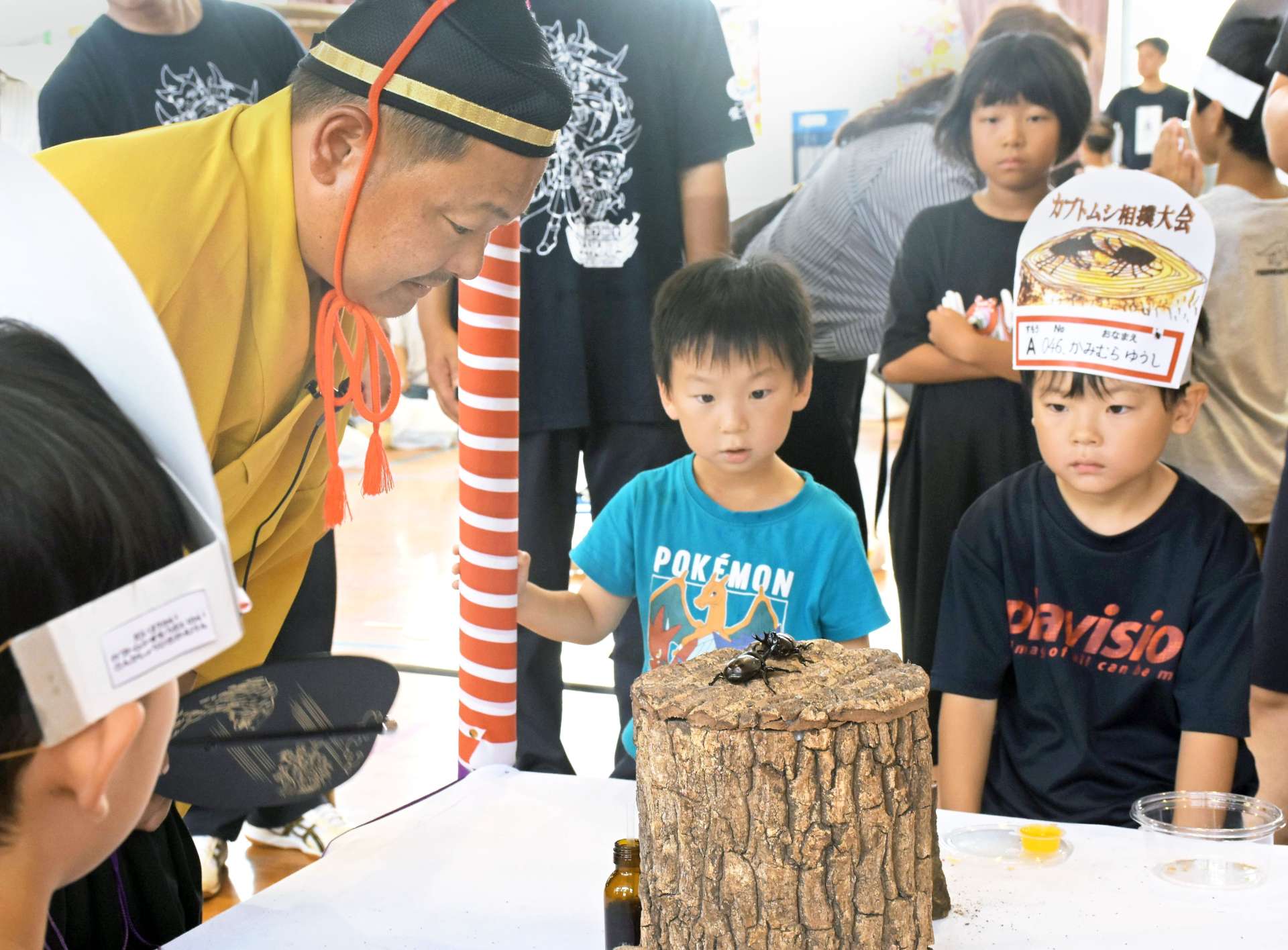 競り合うカブトムシを真剣な表情で応援する子どもたち＝大崎町の大崎小体育館