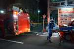 車両火災があったマンション駐車場周辺で作業する署員ら＝２５日、鹿児島市西田２丁目