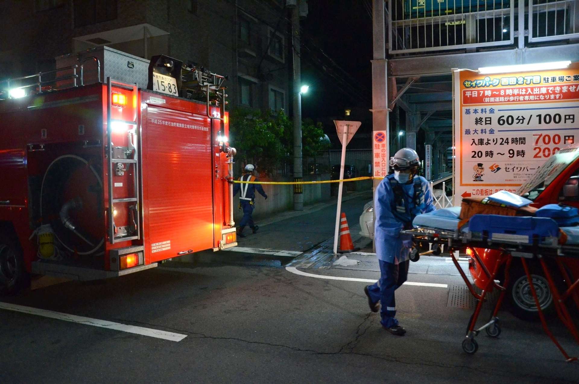 車両火災があったマンション駐車場周辺で作業する署員ら＝２５日、鹿児島市西田２丁目