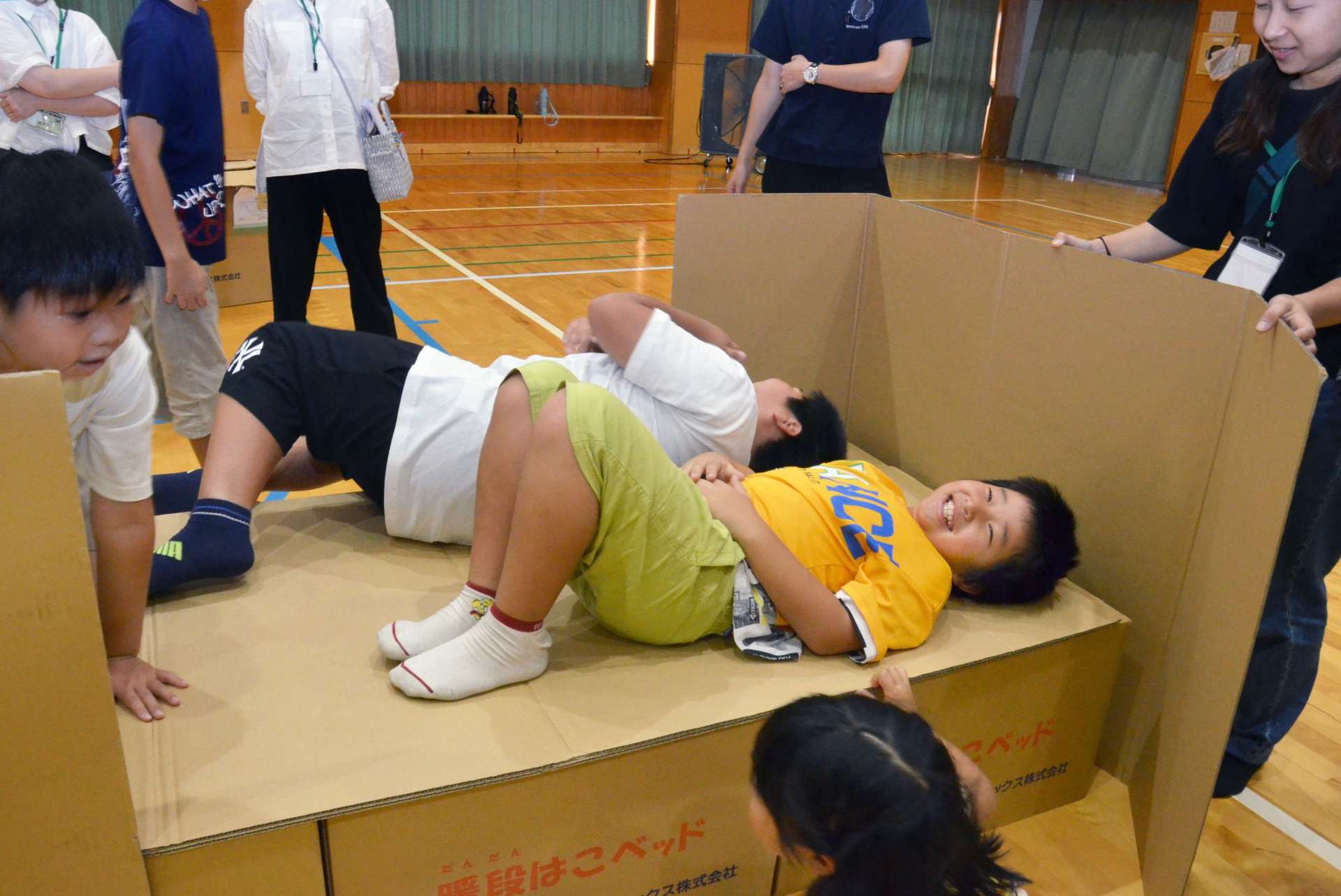 段ボールベッドの寝心地を確かめる児童＝１８日、鹿児島市の鹿児島特別支援学校