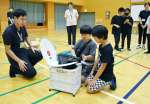 簡易トイレの組み立てに挑戦する児童＝１８日、鹿児島市の鹿児島特別支援学校