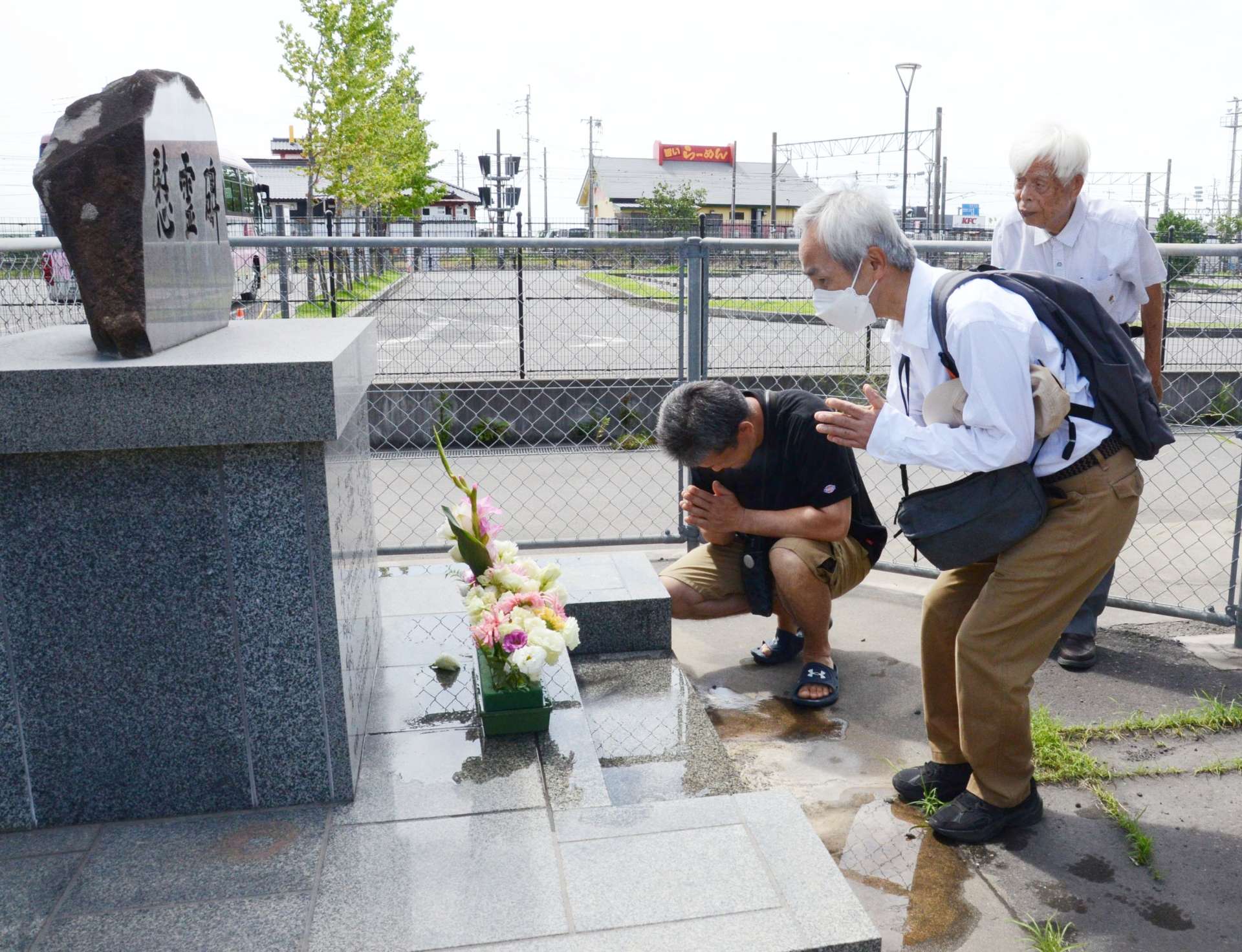 ＪＲ鹿児島駅の慰霊碑に花を手向ける参加者＝２７日、鹿児島市浜町