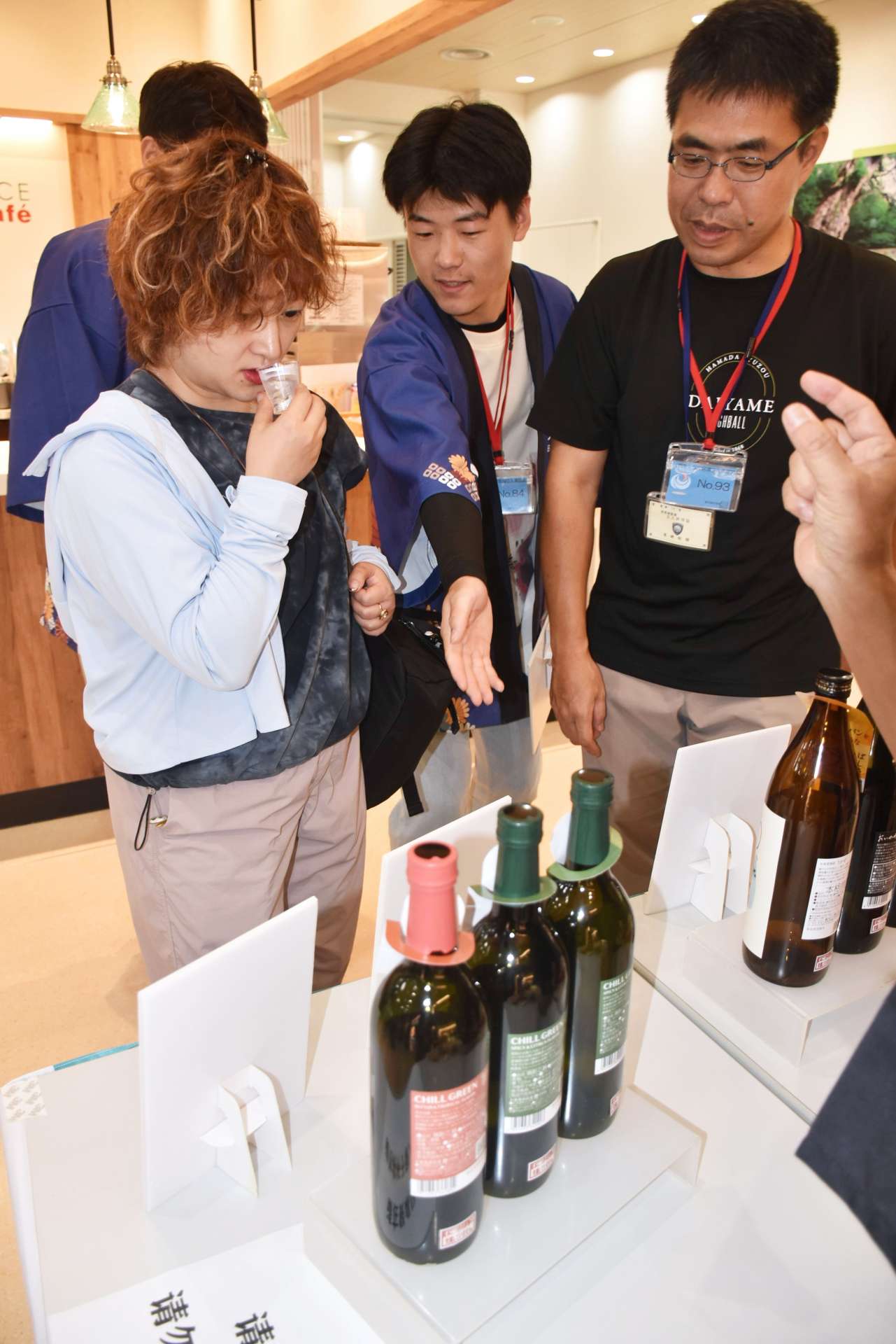 中国人観光客に鹿児島県産焼酎の試飲を勧める浜田酒造社員ら＝霧島市の鹿児島空港国際線ターミナル