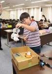 自作の「ＵＦＯメカ」でぬいぐるみを持ち上げる小学生＝鹿児島市郡元２丁目の鹿児島大学