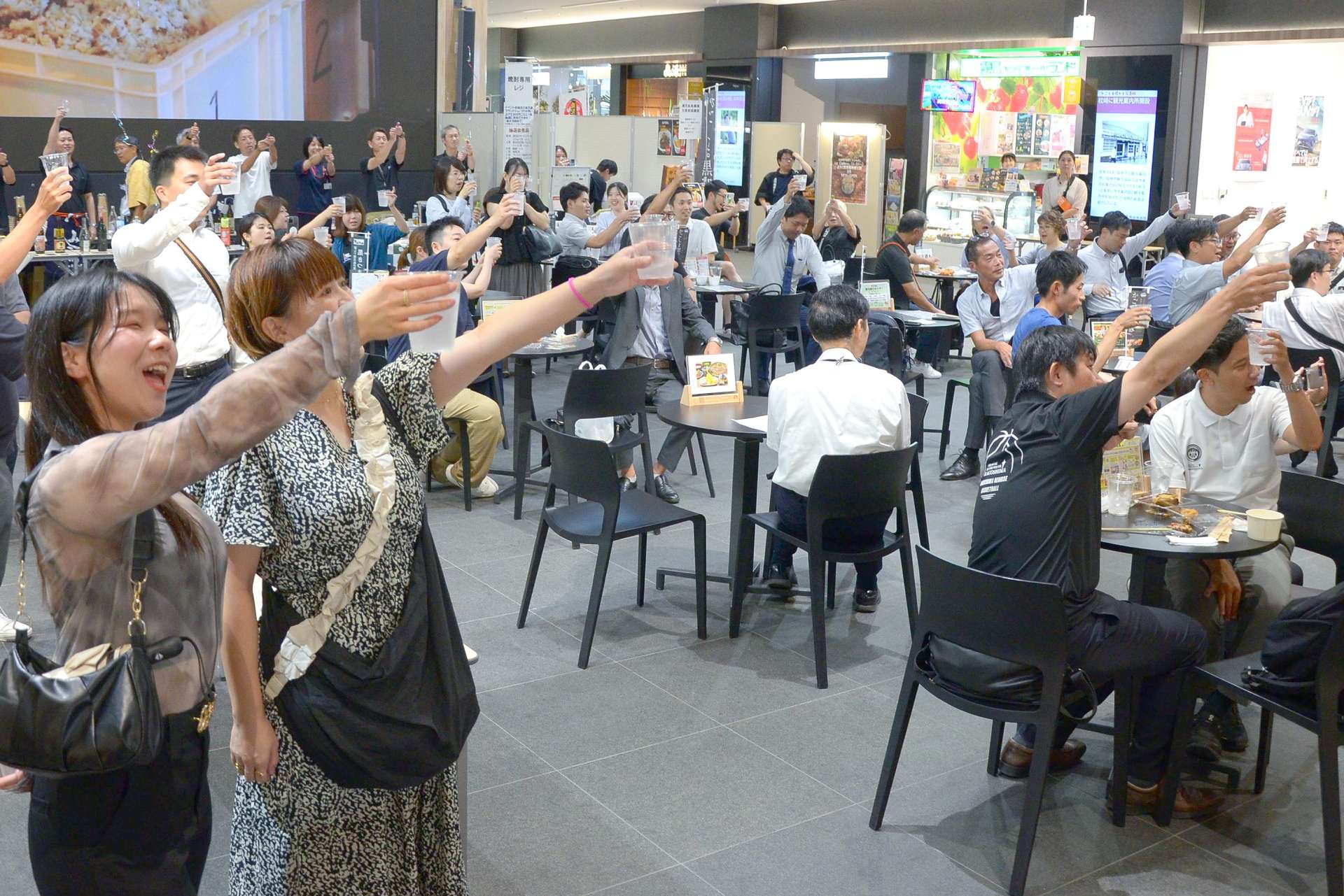 焼酎を片手に一斉乾杯する来場者ら＝１日、鹿児島市のよかど鹿児島