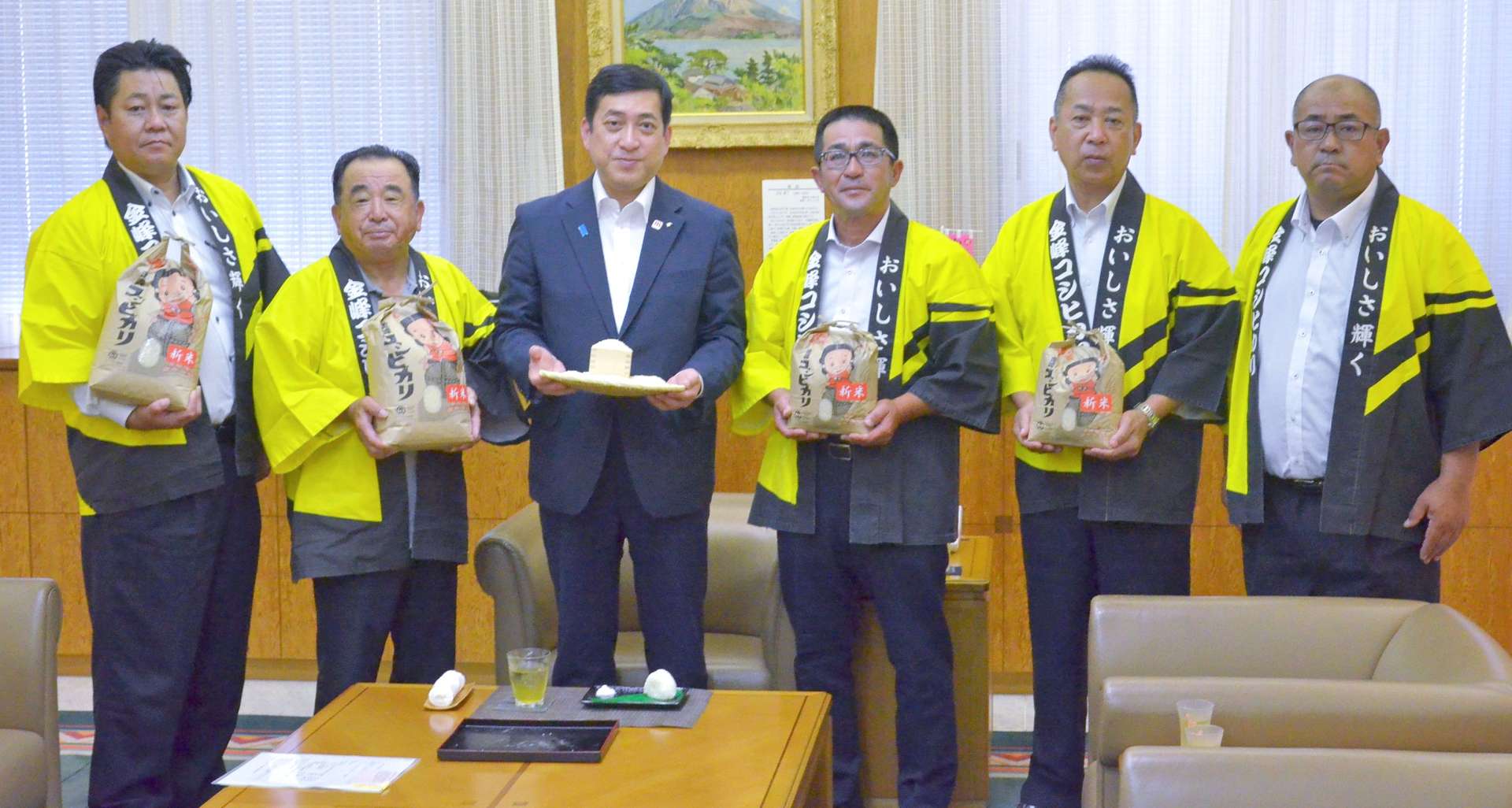 金峰コシヒカリの新米をＰＲするＪＡさつま日置金峰地区水稲部会の本町雄三部会長（右から３人目）ら＝１日、鹿児島県庁
