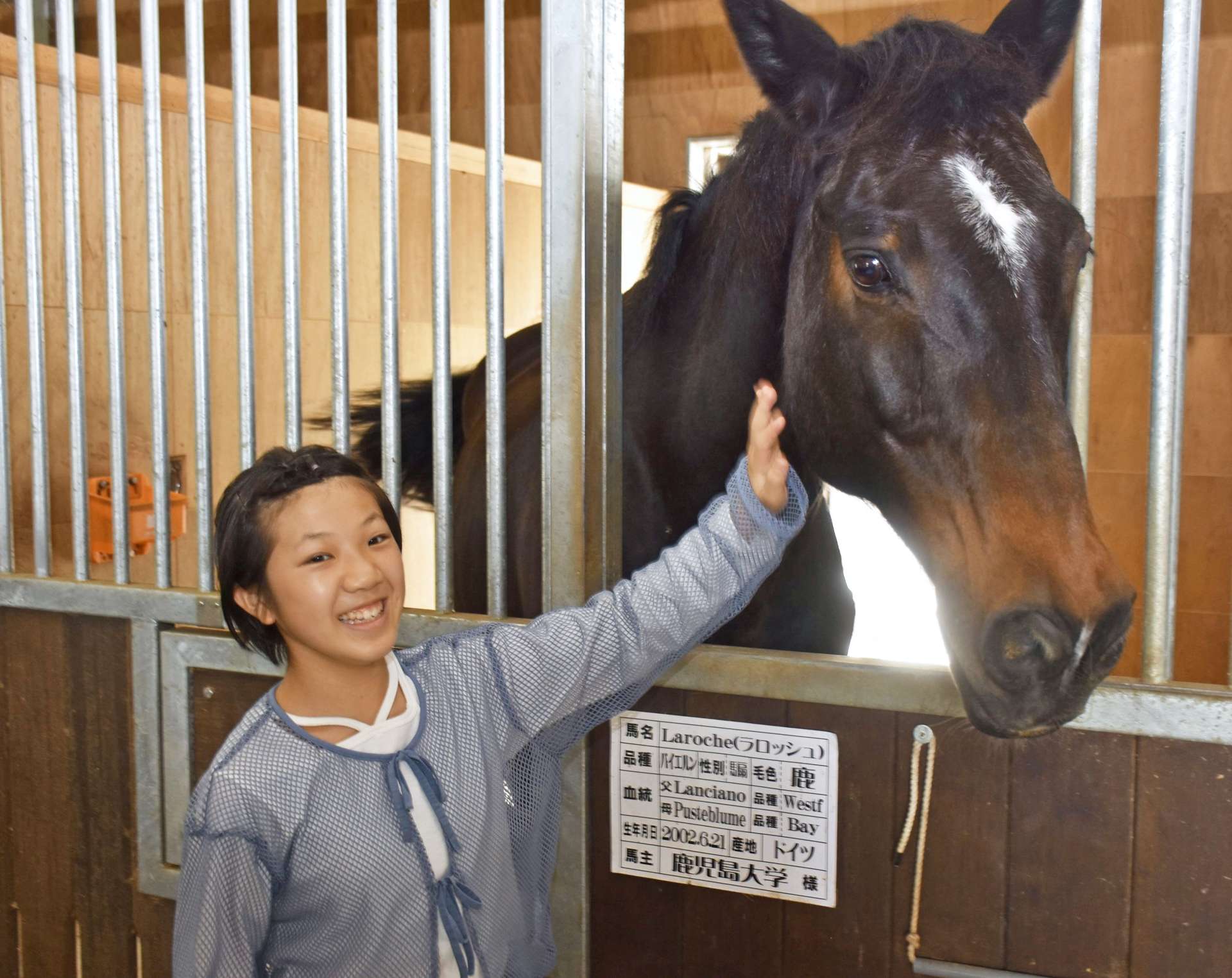 馬と触れ合う石黒櫻さん＝曽於市財部の南九州畜産獣医学拠点