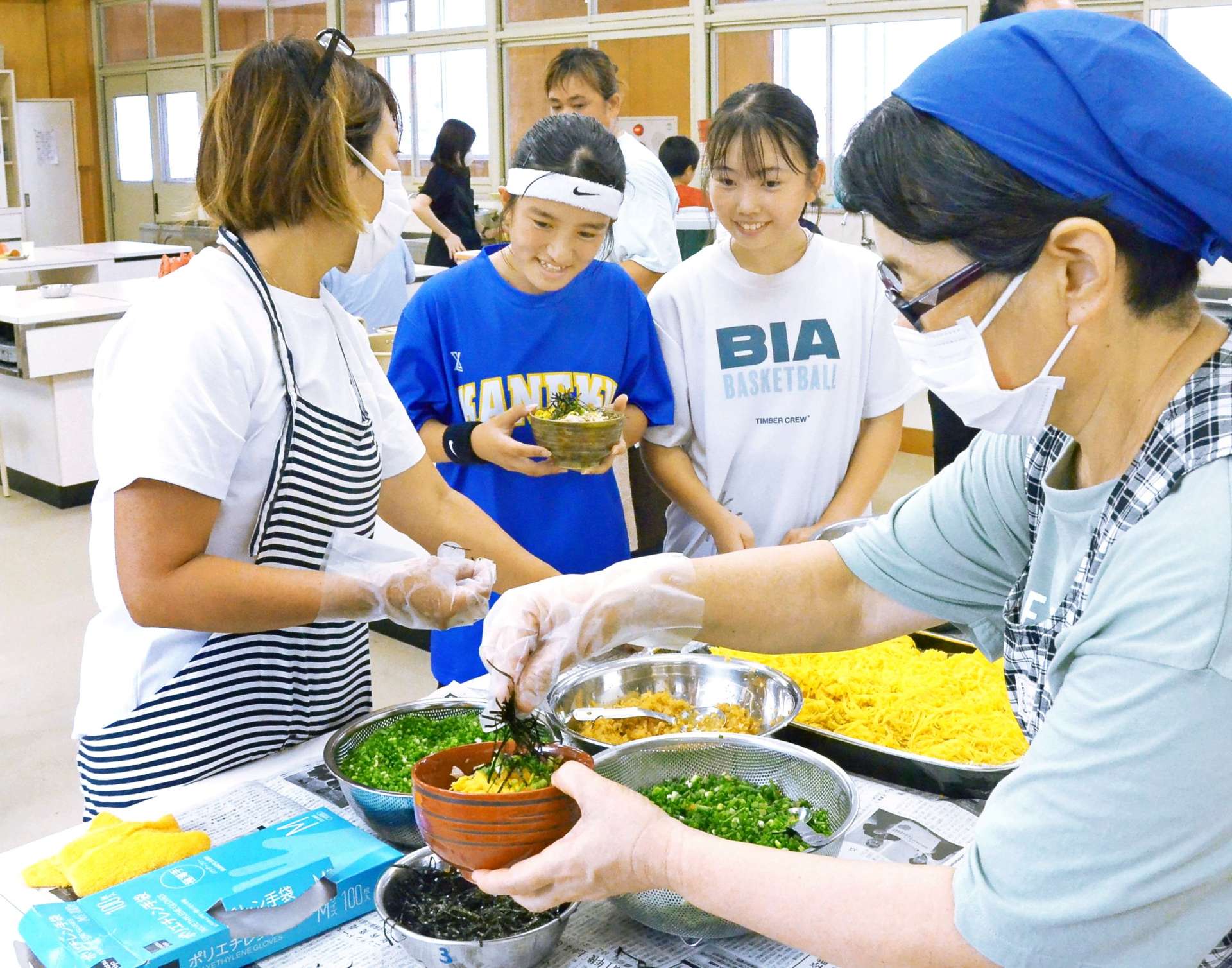 鶏飯を提供するスクールソーシャルワーカー（右）＝奄美市名瀬の金久中学校