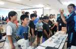 半導体についての説明に耳を傾ける小学生＝日置市のレゾナック・オプトエレクトロニクス鹿児島