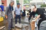 たいまつ作りを楽しむ鹿児島大学の学生（右）＝南大隅町根占山本の宮田小学校跡