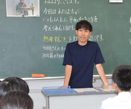 〈関連〉黒板に「８０年前のことを想像してほしい」と書き、児童に話しかける野元祥太郎さん＝６日、広島市南区の広島大学付属小学校