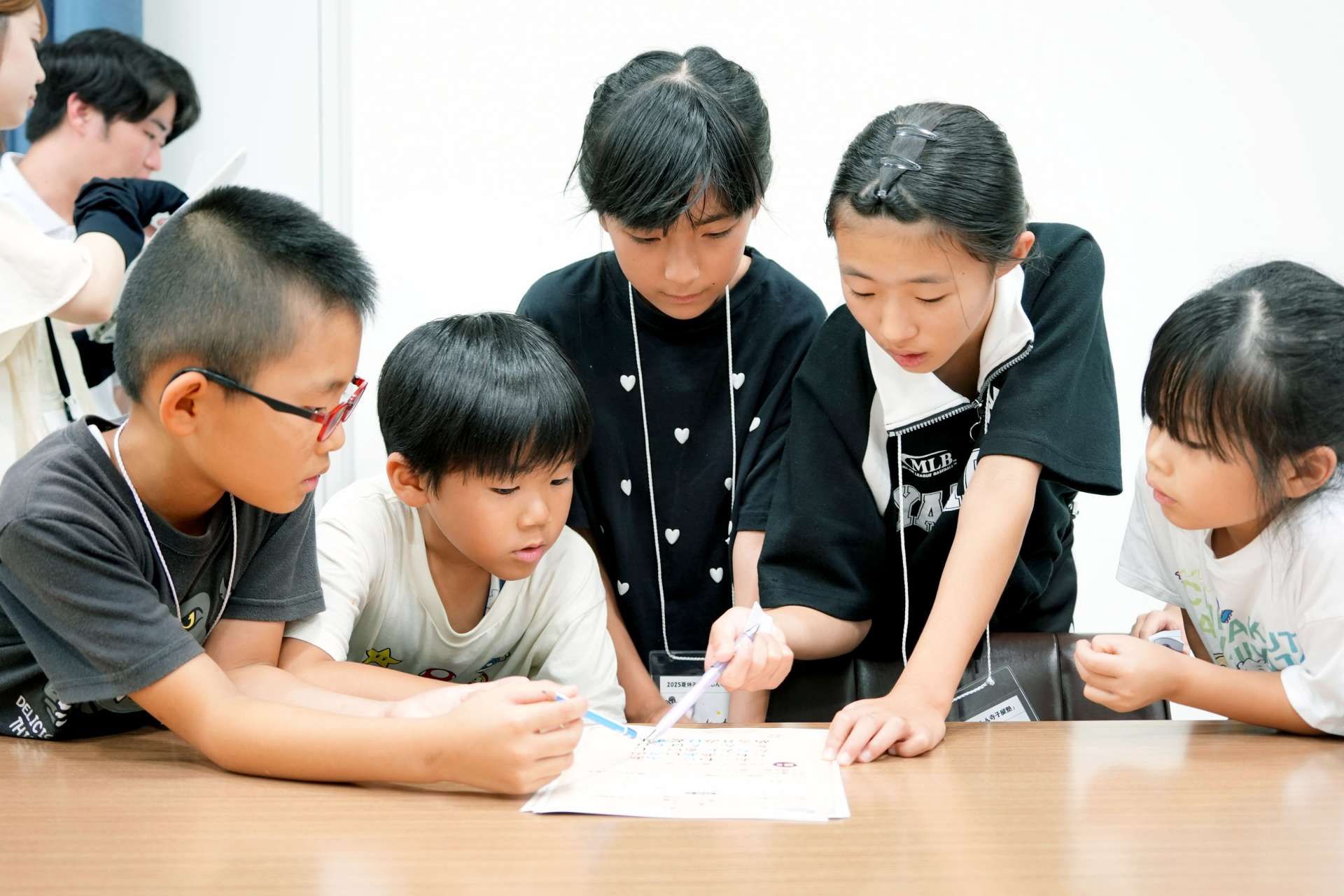 協力して謎を解く子どもたち＝７日、鹿児島市与次郎１丁目の鹿児島相互信用金庫本部