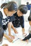 協力して謎を解く子どもたち＝７日、鹿児島市与次郎１丁目の鹿児島相互信用金庫本部
