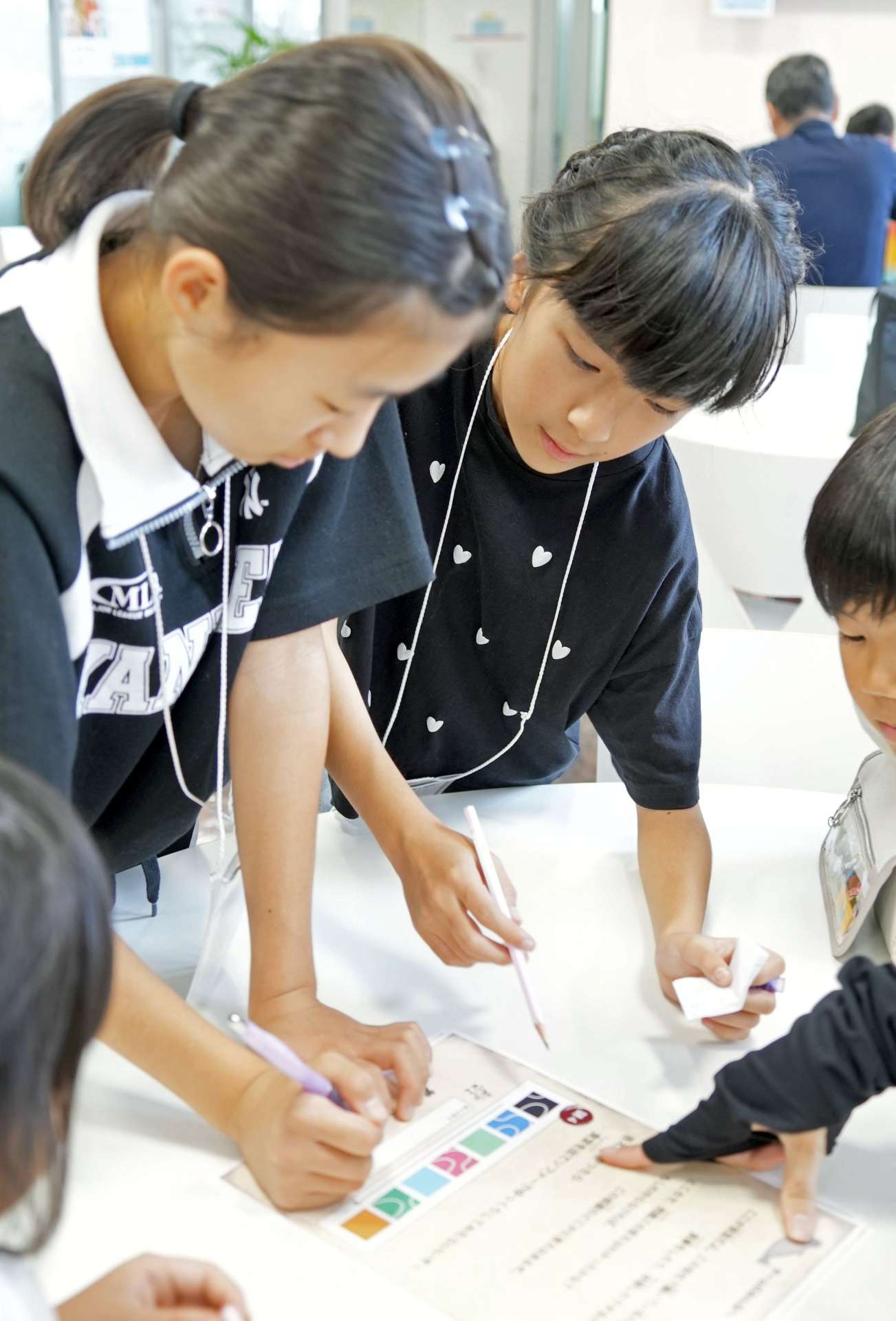 協力して謎を解く子どもたち＝７日、鹿児島市与次郎１丁目の鹿児島相互信用金庫本部