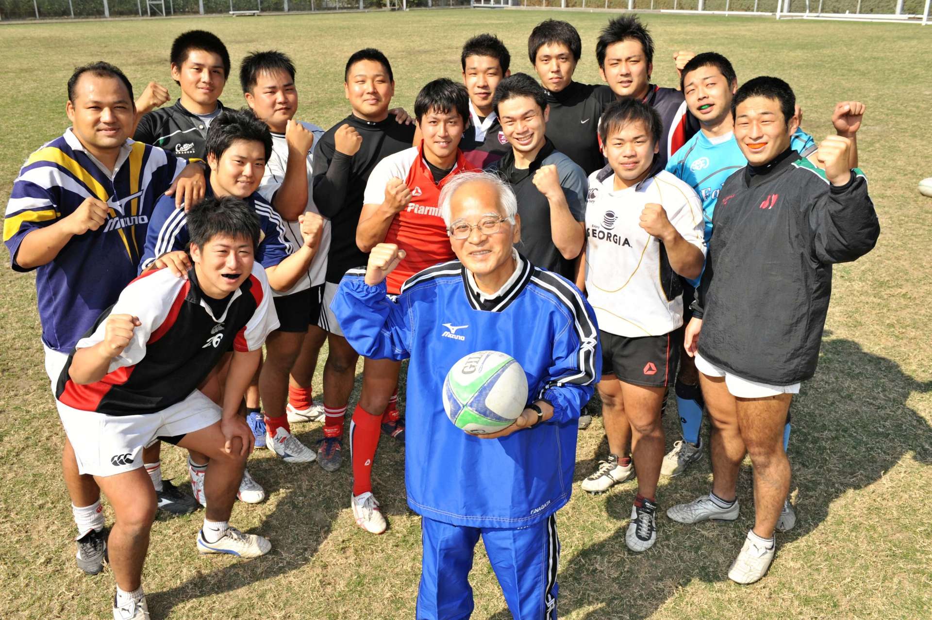 鹿児島銀行の頭取在任中もラグビー部の総監督をしていた永田文治さん（中央）＝２００９年１０月、鹿児島市の鹿児島銀行グラウンド