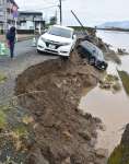 川沿いの道路が崩落し川に転落した車両＝８日午前８時５０分、姶良市加治木町港町の網掛川（画像は一部加工しています）