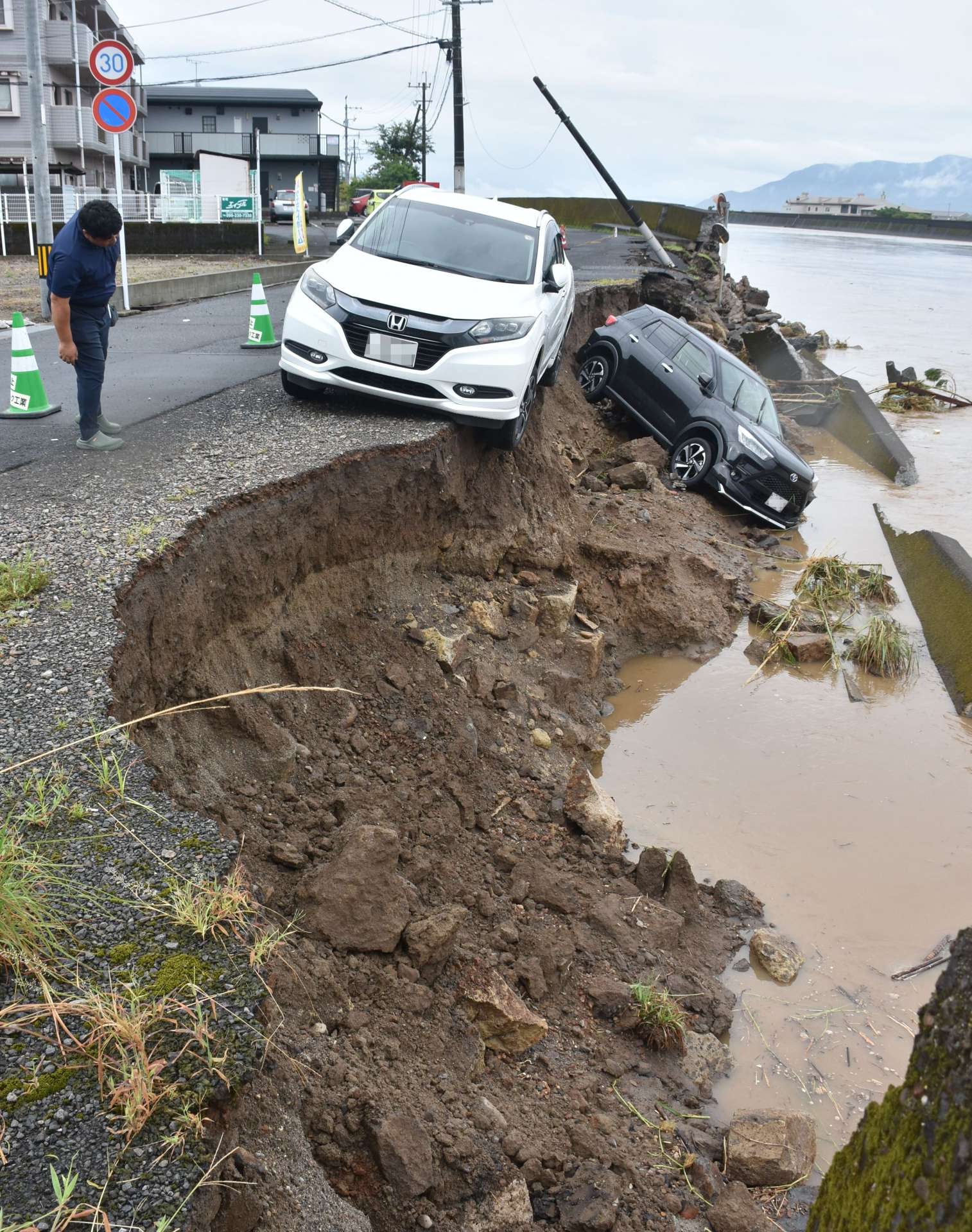 川沿いの道路が崩落し川に転落した車両＝８日午前８時５０分、姶良市加治木町港町の網掛川（画像は一部加工しています）