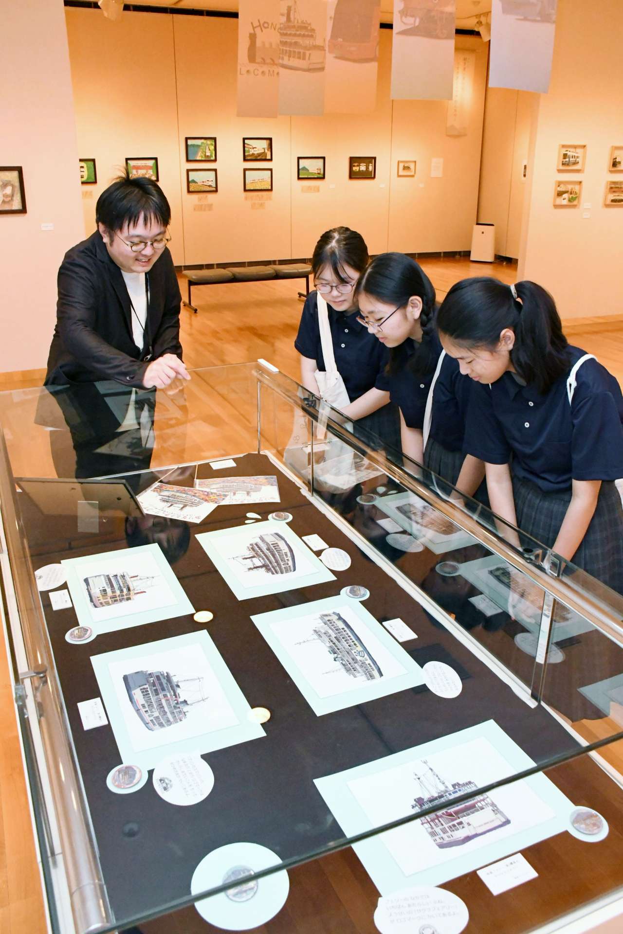中学生に作品解説する冨吉郷太さん（左）＝鹿児島市の長島美術館