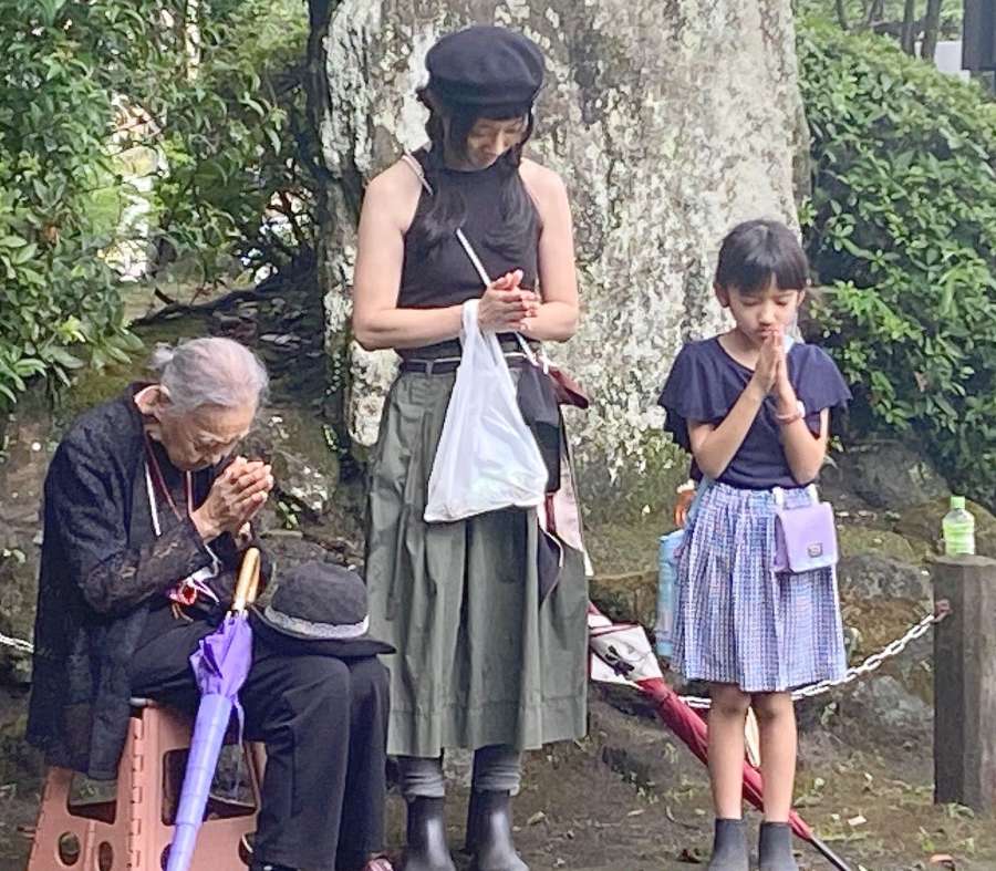 孫やひ孫とともに手を合わせ、原爆の犠牲者を追悼する桐原スズ子さん（左）＝９日午前１１時２分、鹿児島市の探勝園