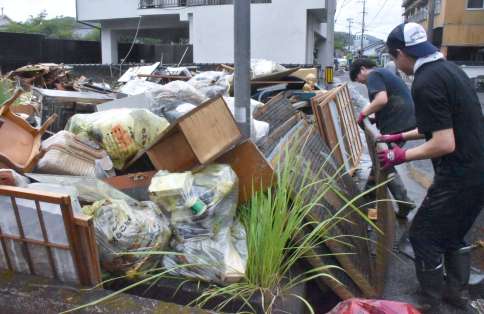 〈何もかもがだめに…〉水に浸かった家財道具が積み上げられた仮置き場＝９日午後１時１０分ごろ、霧島市隼人町内