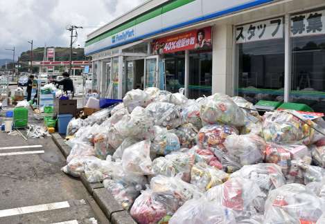 大雨の影響で水没し清掃作業に追われるコンビニエンスストア＝９日午後１時半ごろ、姶良市加治木