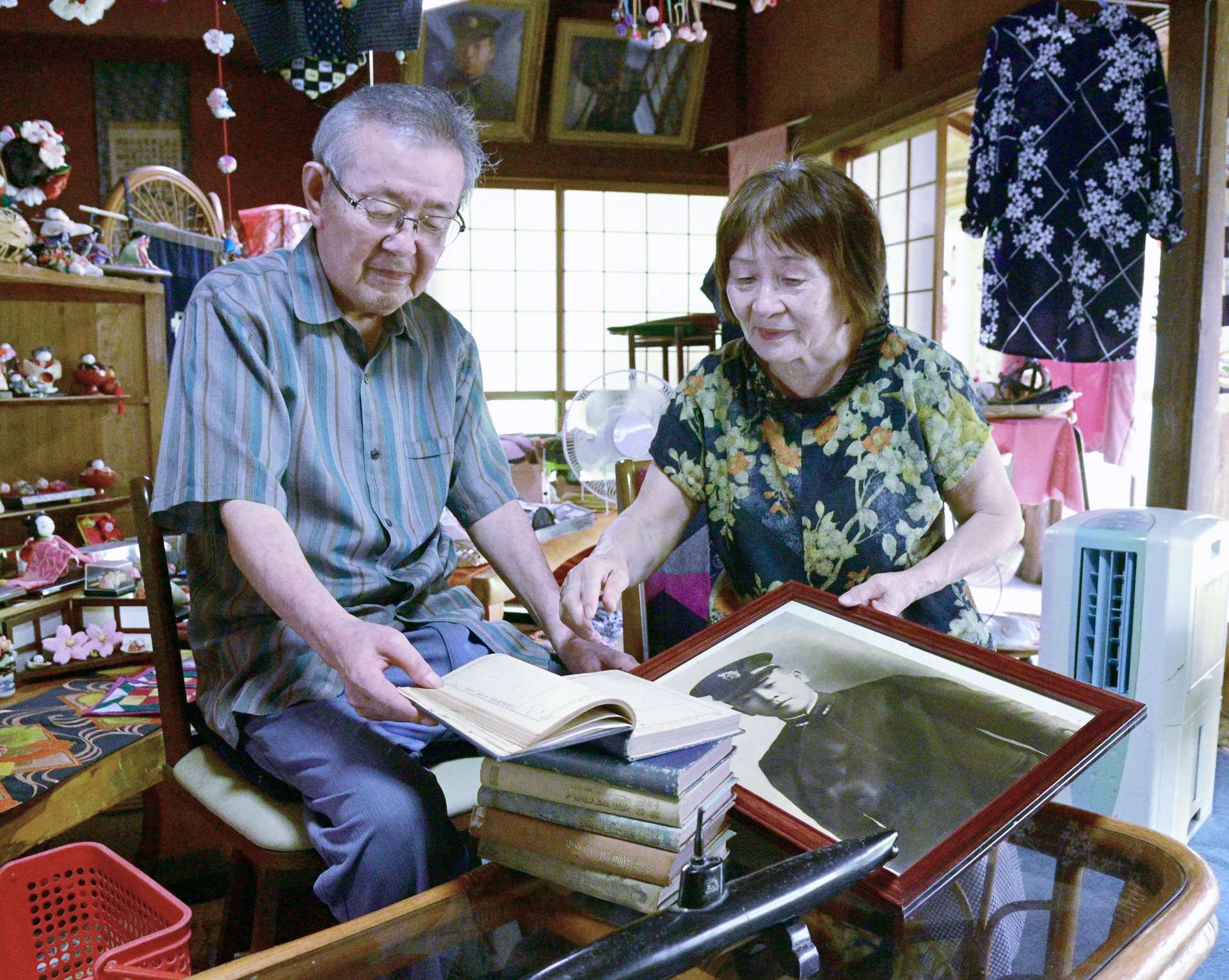 中馬兼四隊員の日記を見るおいの知敷憲一郎さん、成子さん夫妻＝６日、薩摩川内市東郷町鳥丸