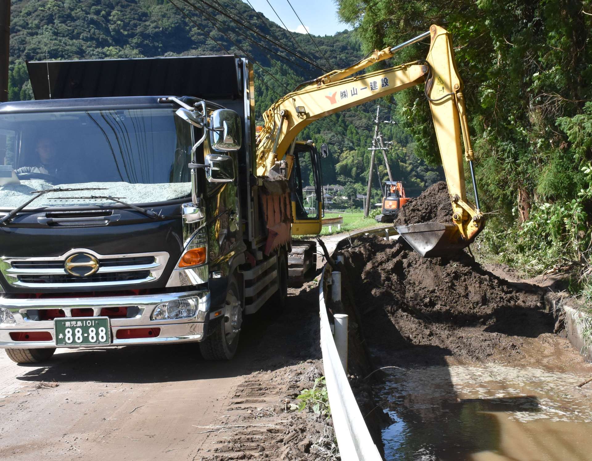農業用水路に流れ込んだ土砂の撤去作業＝１３日、霧島市隼人町松永