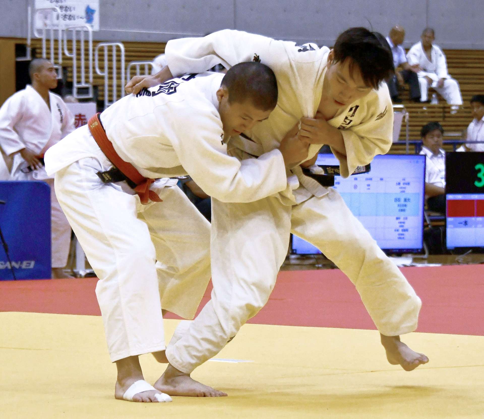 男子６６キロ級個人２回戦、足技から投げ技に持ち込む川内商工の西ノ原（右）＝ジップアリーナ岡山