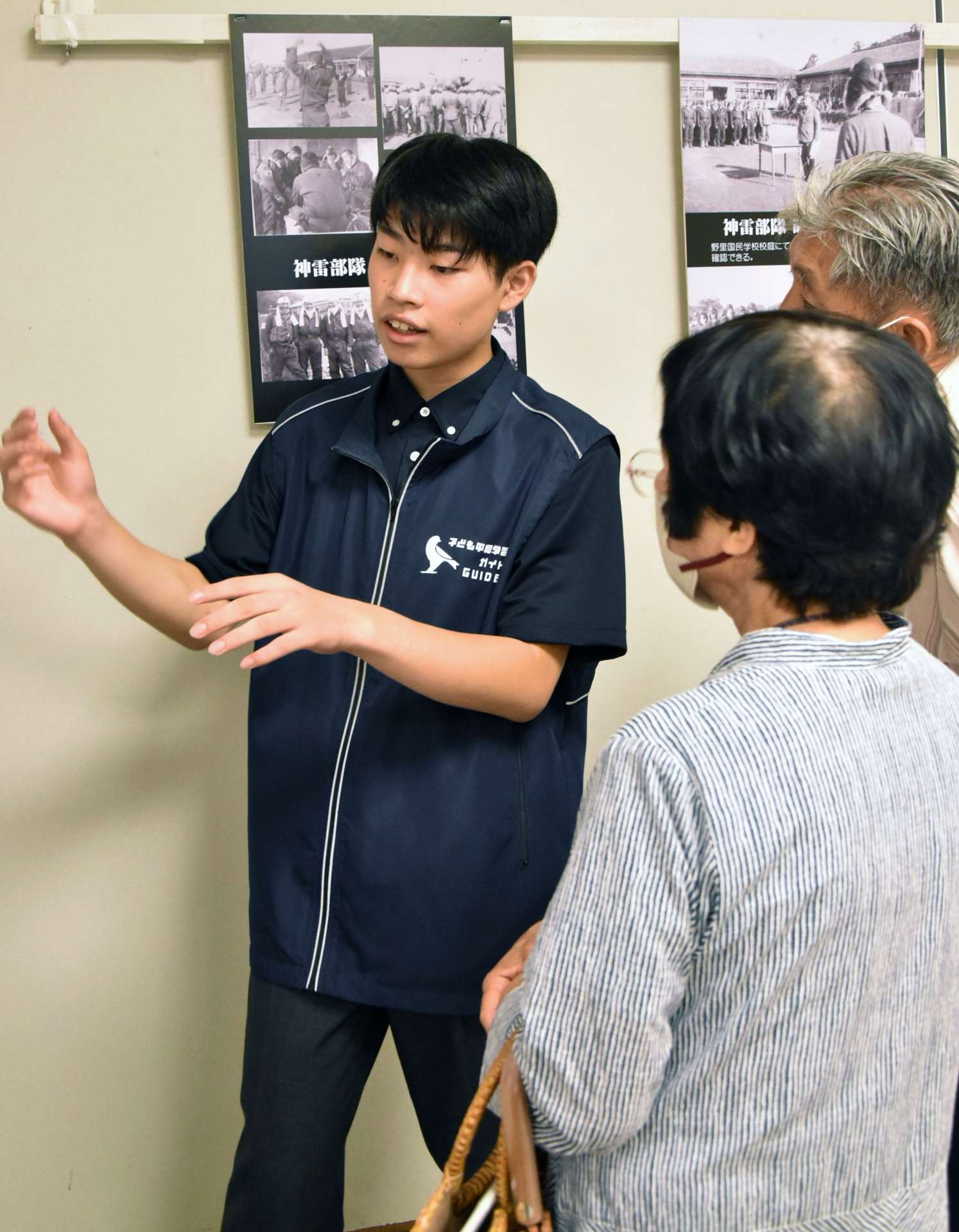 「若い世代が戦争を知らないままでいるのはまずい」との思いで来場者をガイドする小石田蒼麿さん＝８日、鹿屋市のリナシティかのや