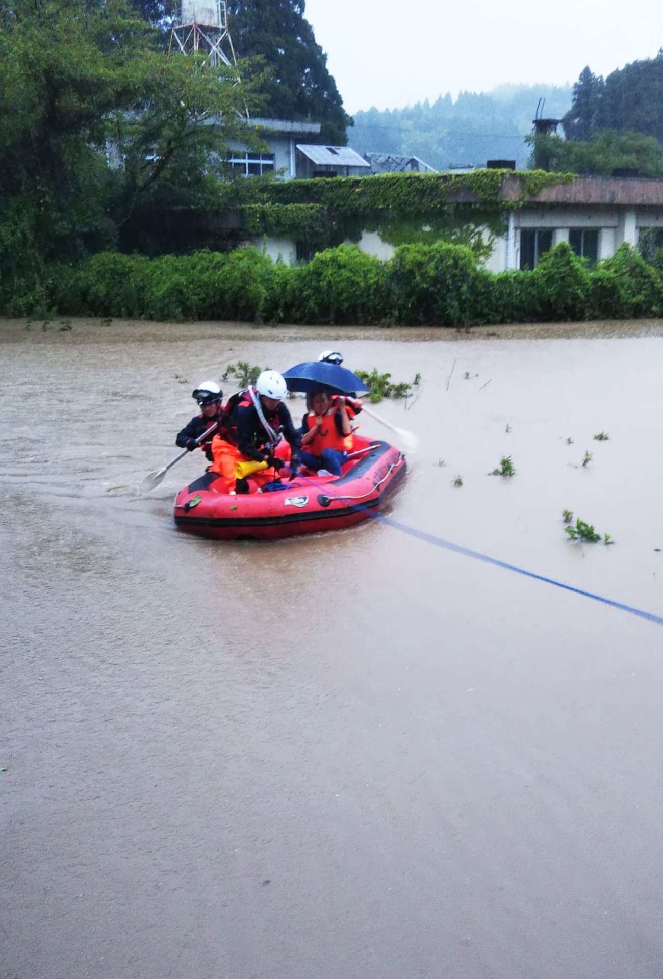 〈関連〉冠水した家屋の住民をボートで避難させる消防隊員＝８日午前６時半ごろ、曽於市末吉町岩崎（大隅曽於地区消防組合提供）