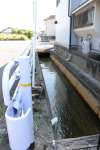 〈幅は１.５メートル〉男性が転落した市道脇の水路。時間帯によっては高温の温泉水が流れる＝１６日、指宿市大牟礼３丁目