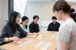 地域交通を題材にしたカードゲームを楽しむ志學館大学の学生ら＝鹿児島市の同大
