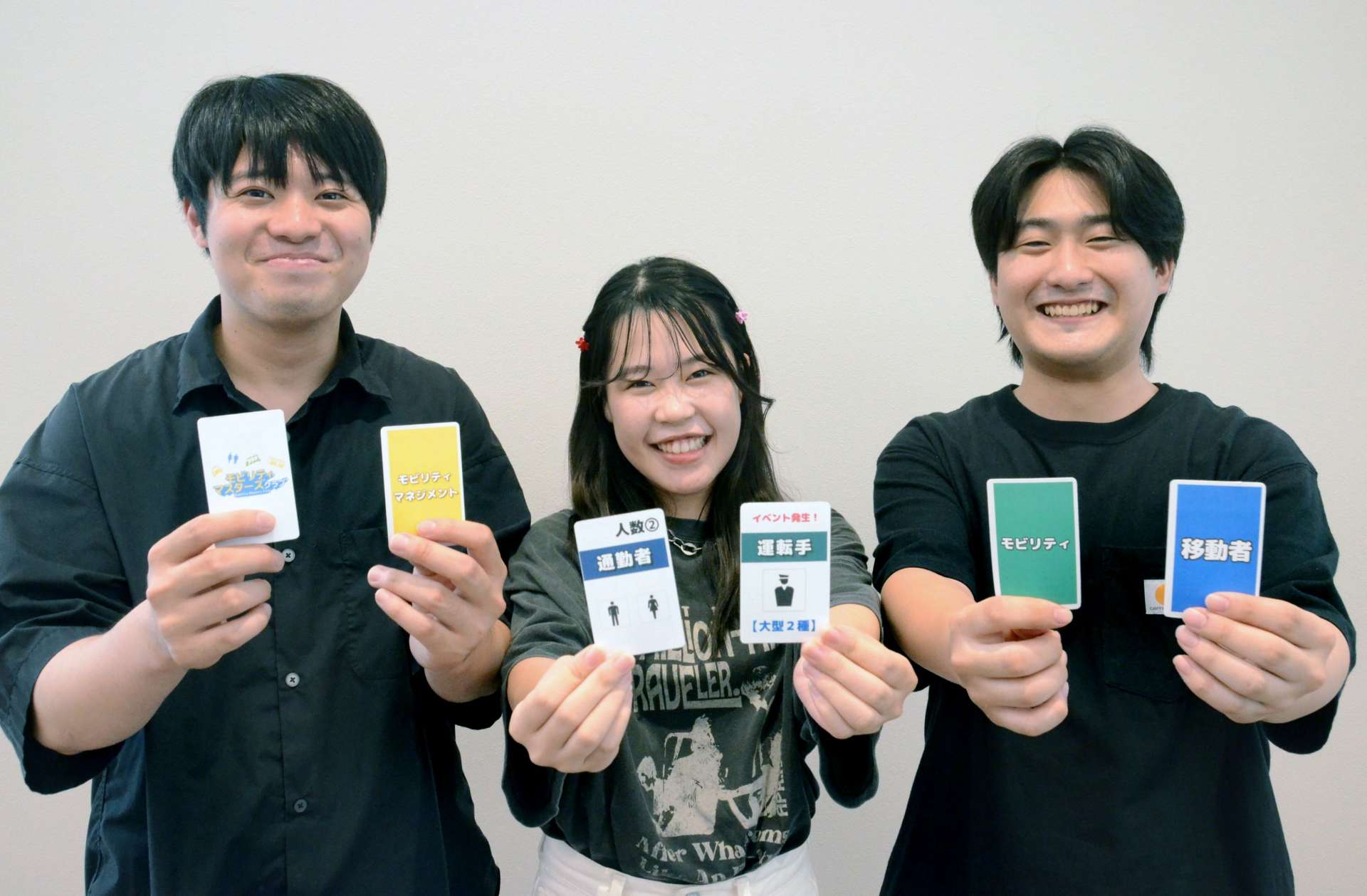「ぜひ印刷して遊んで」と地域交通を題材にしたカードゲームをＰＲする学生＝鹿児島市の志學館大学
