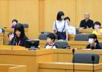 鹿児島市議会の議場で質問をする参加者＝同市役所