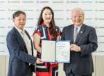 肉用牛生産で出る温室効果ガス（ＧＨＧ）排出量削減のボランタリークレジット発行証書を披露するＪＡ鹿児島県経済連の柚木弘文会長（右）（同連提供）