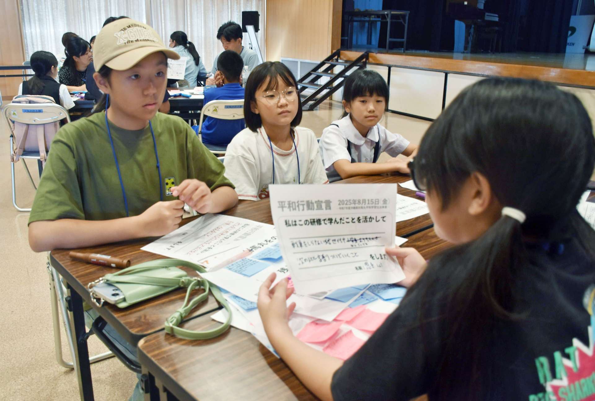対馬丸事件の継承方法などについての考えを発表し合う小中学生ら＝宇検村の生涯学習センター