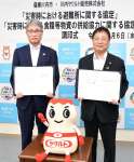 協定書を手にする川内ヤクルト販売の影山俊二社長（左）＝薩摩川内市役所