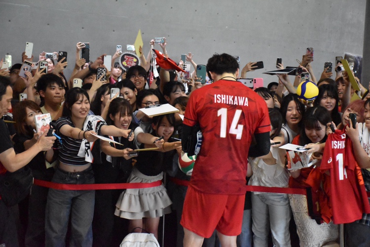 〈美しい背中、ファン悶絶〉サインする石川祐希選手＝１７日、薩摩川内市のサンアリーナせんだい
